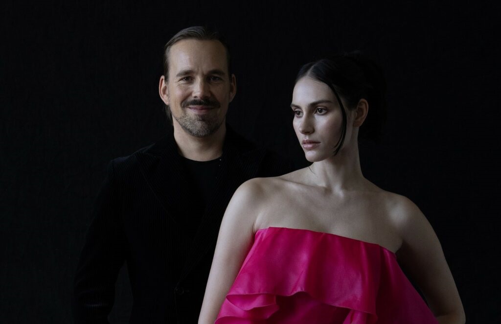 Teemu Muurimäki posing with the model. Model has pink gown designed by Muurimäki.